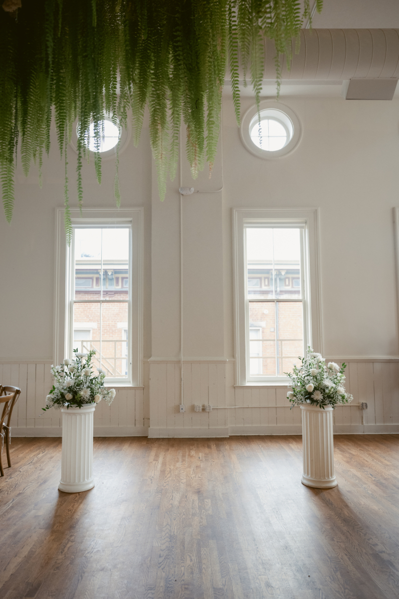 White floral arrangements on pillars set for a Downtown Cincinnati Wedding ceremony at The Alcove.