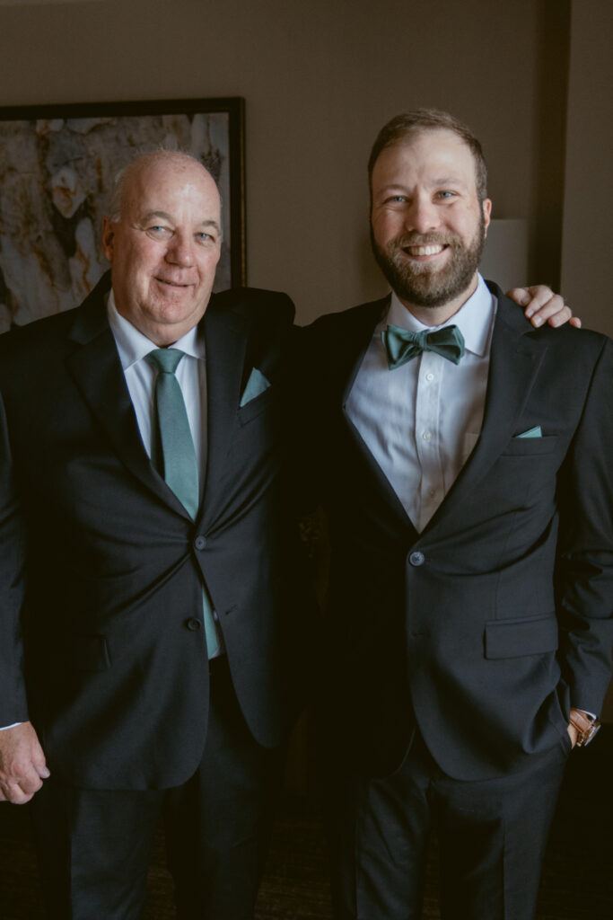 Groom and father smiling in suits before a Downtown Cincinnati Wedding celebration.