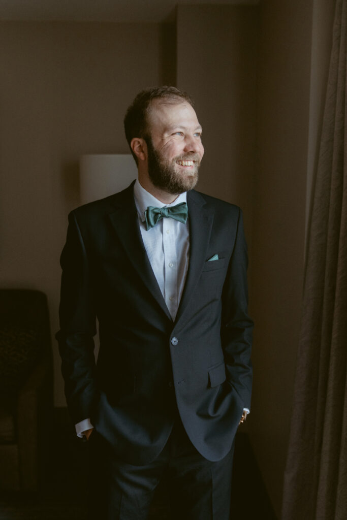 Groom smiling while looking out a window before his Downtown Cincinnati Wedding ceremony.