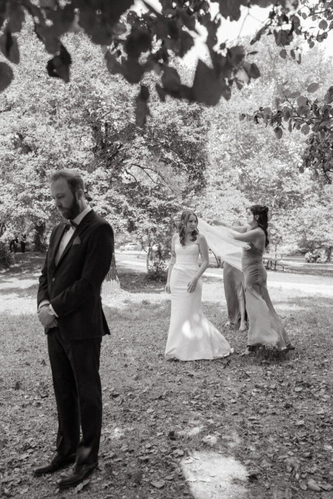 Groom waiting with eyes closed as bride prepares for their first look at a Downtown Cincinnati Wedding.