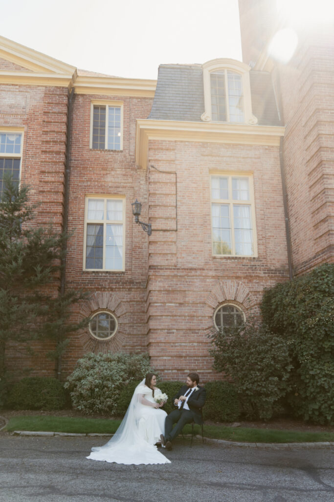Bride and groom share quiet moment seated outside historic mansion during their Ohio garden wedding.