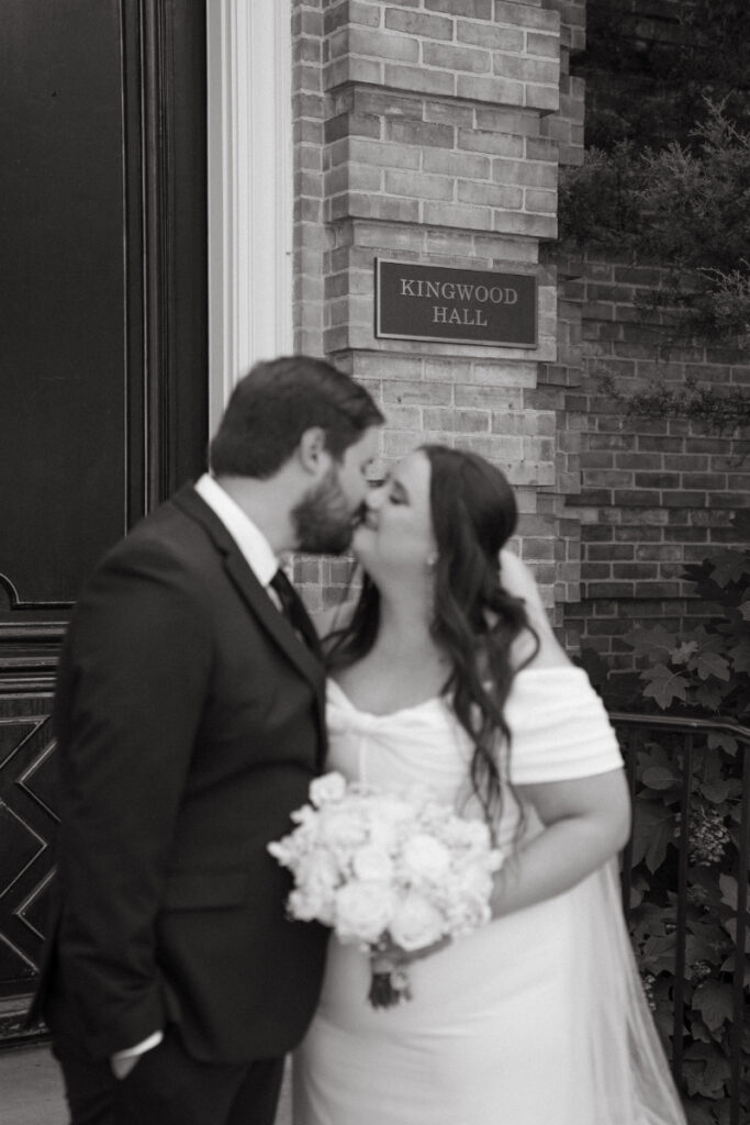 Black and white photo of bride and groom sharing a kiss during their Ohio garden wedding.