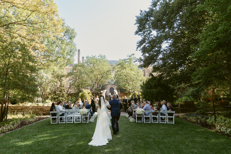 Bride walks down the aisle with her father at outdoor ceremony during Ohio garden wedding at Kingwood.