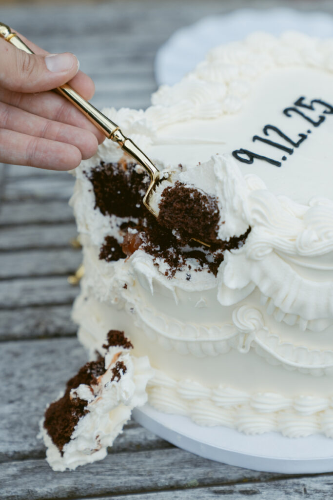 Close-up of chocolate wedding cake being sliced during an elegant Ohio garden wedding celebration.