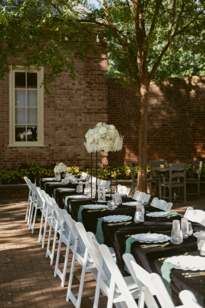 Elegant outdoor reception setup with black linens and white florals during Ohio garden wedding at Kingwood.