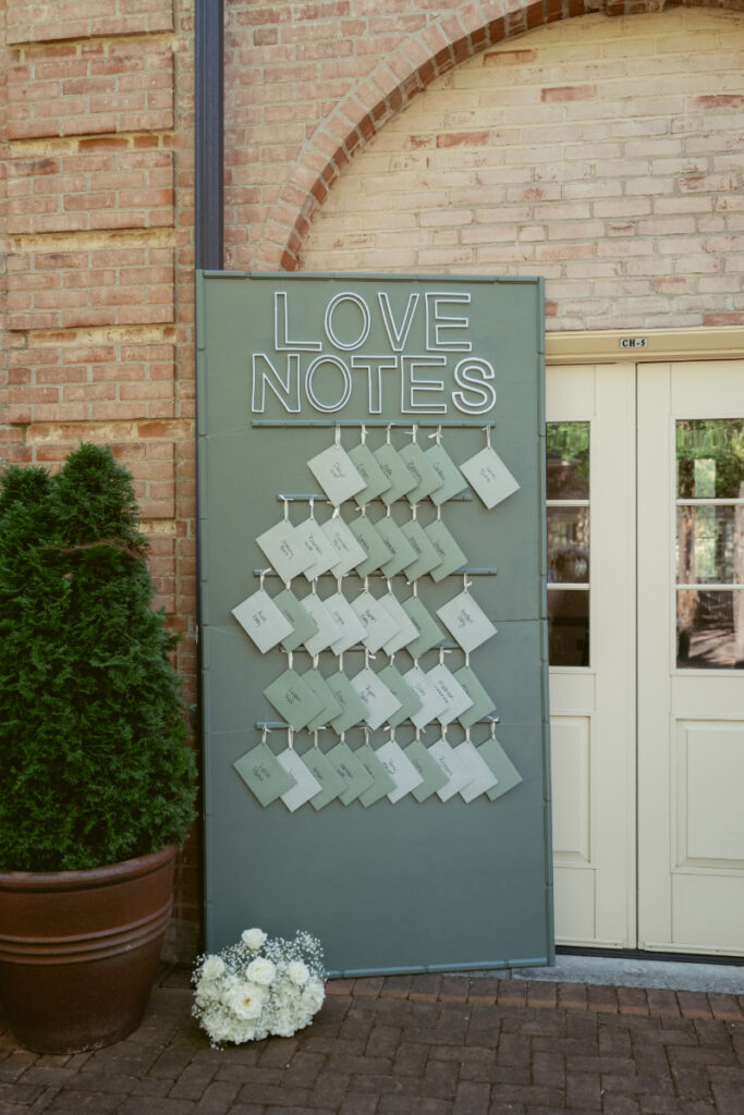 Love notes display with handwritten messages for guests at a thoughtful Ohio garden wedding reception.