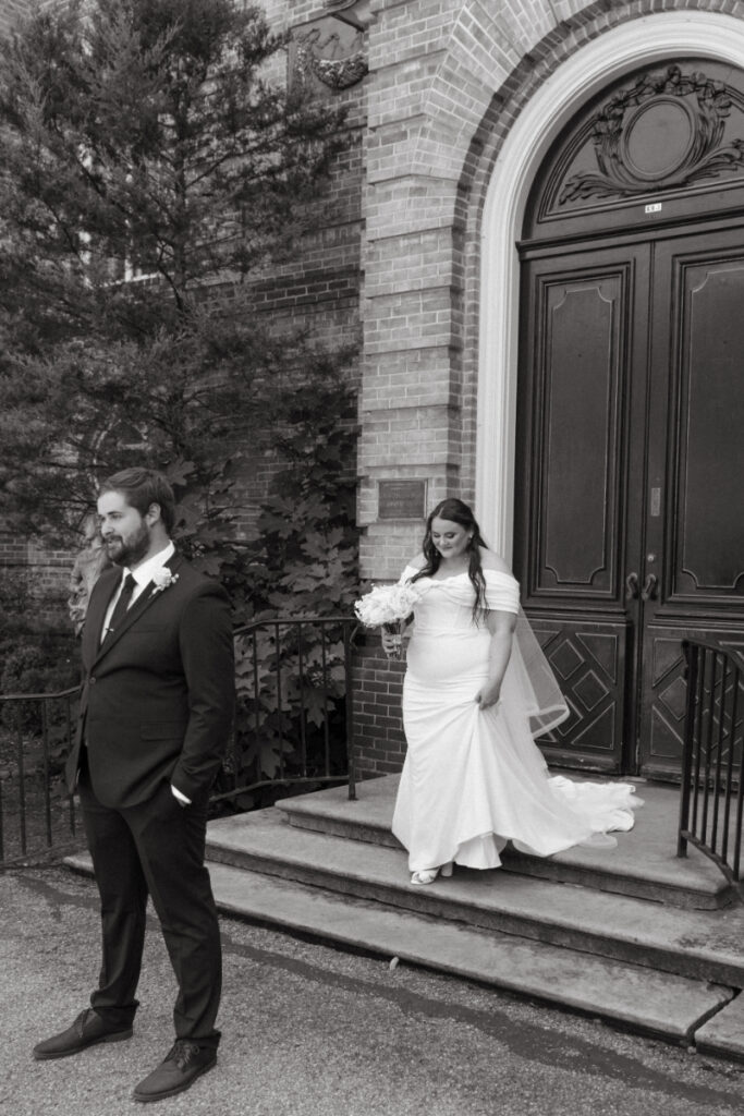 Black and white photo of bride approaching groom for first look at their Ohio garden wedding.