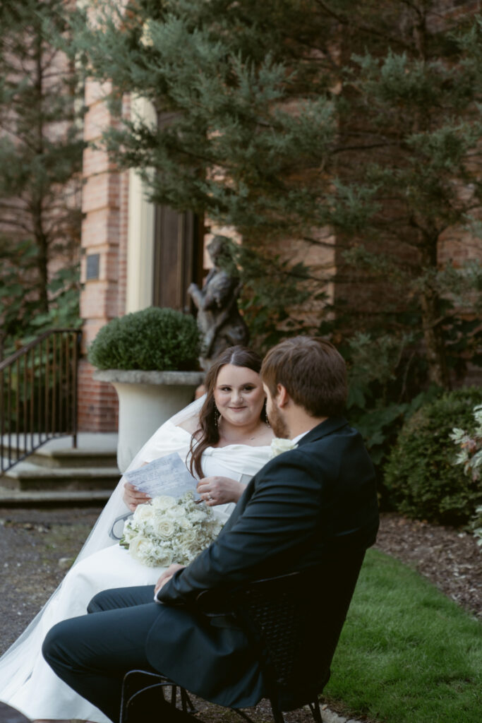 Bride holds vow booklet while sharing private moment with groom during Ohio garden wedding at Kingwood.