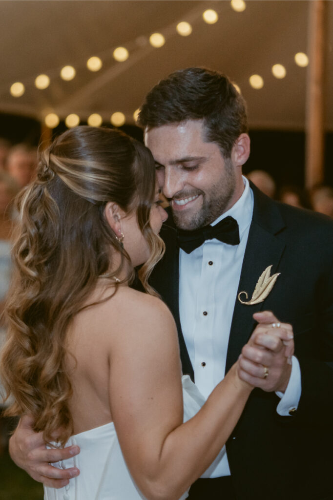 bride and groom smiling while danving with eachother on their wedding day