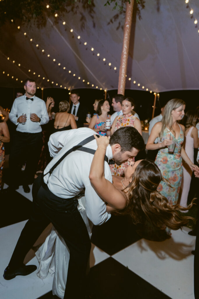 bride and groom sharing a kiss while dancing at their wedding reception