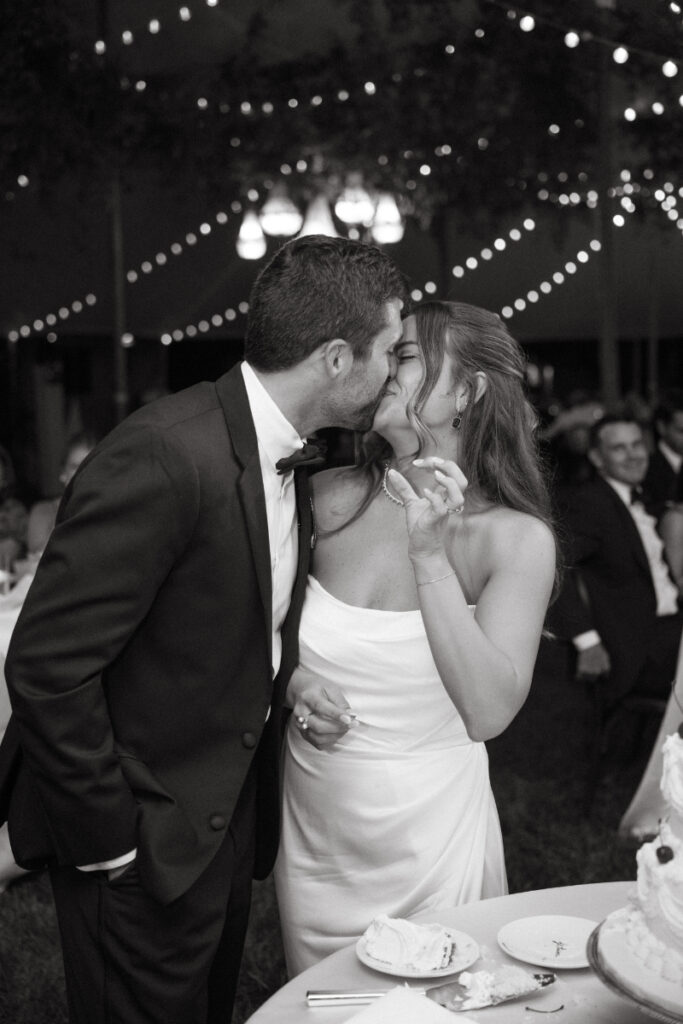 bride and groom kissing after they cut the cake