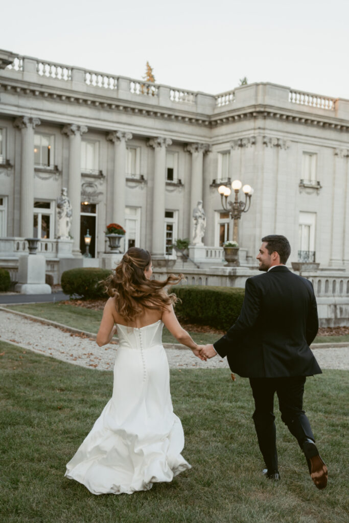 bride and groom running hand in hand on their wedding day at Laurel Court