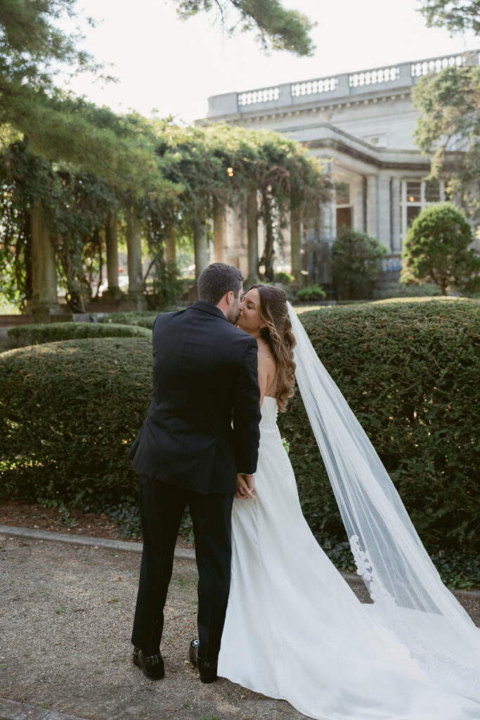 Bride walking up stone steps holding her dress and veil during a Laurel Court wedding.