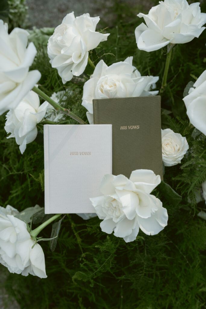 Two “His Vows” books surrounded by white roses at elegant Laurel Court wedding in Cincinnati.