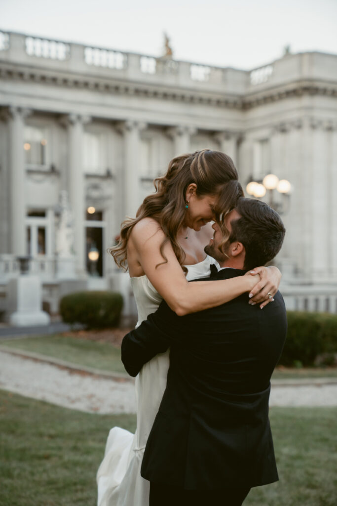 bride and groom share a loving embrace on the ground of their Laurel Court wedding