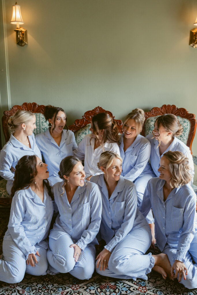 Bride and bridesmaids in matching pajamas sharing a fun moment before a Laurel Court wedding.