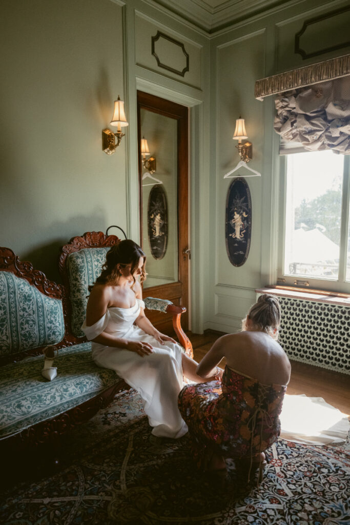 Bride getting ready with help in vintage bridal suite before her Laurel Court wedding ceremony.