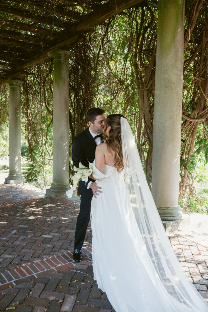 Bride and groom smiling during their first look under the pergola at their Laurel Court wedding.