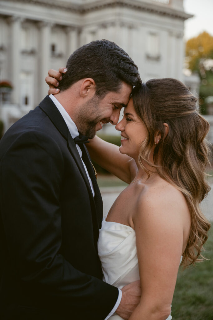 Bride and groom smiling forehead to forehead outside during their romantic Laurel Court wedding.