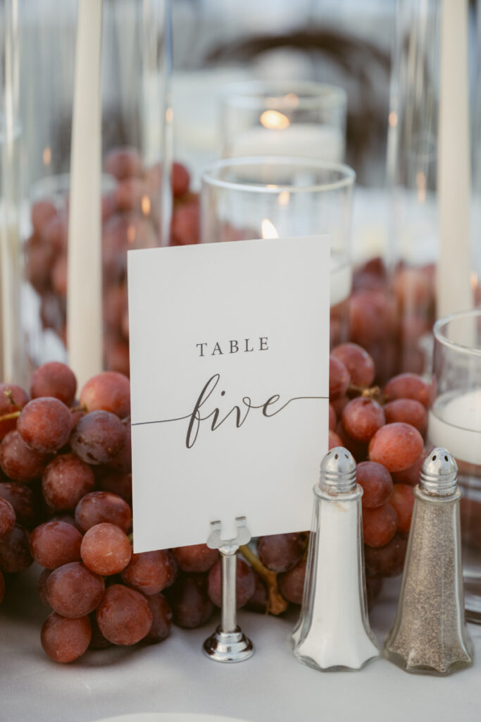table number 5 with candles, grapes and salt and pepper shakers