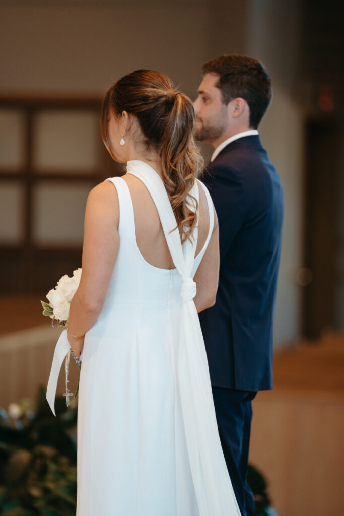 Bride and groom standing side by side during church ceremony before their Laurel Court wedding.