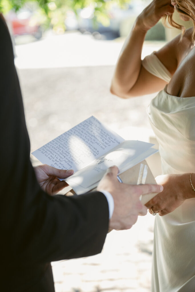 Bride and groom reading handwritten vows during a private moment at their Laurel Court wedding.