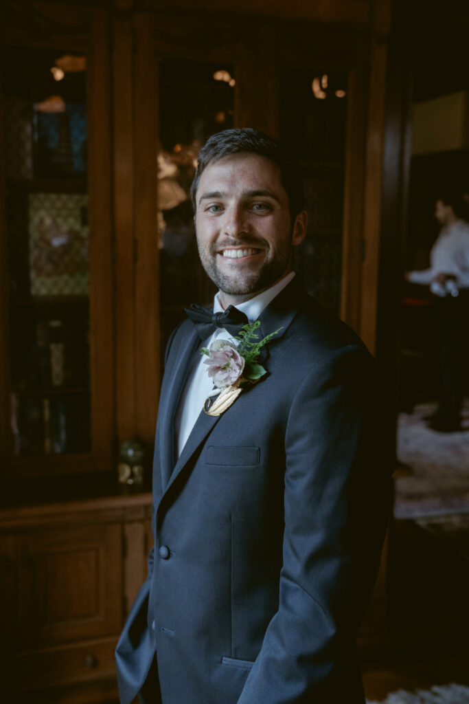 Groom smiling in a tux with boutonniere before the start of his Laurel Court wedding.