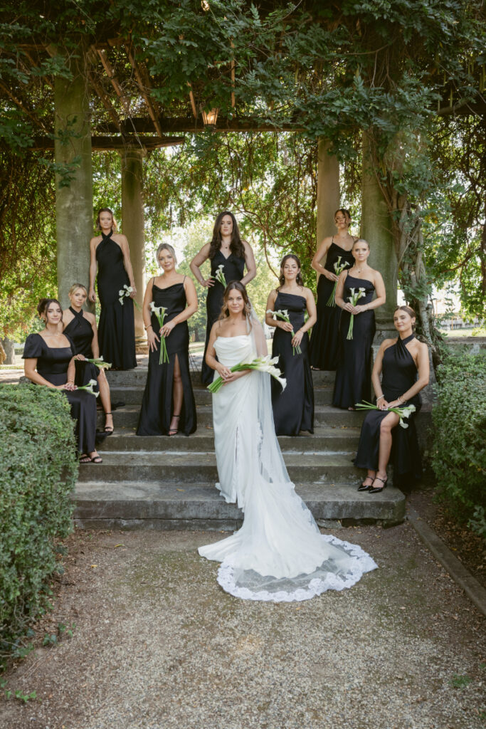 Bride poses with bridesmaids in black dresses at romantic Laurel Court wedding in Cincinnati, Ohio.