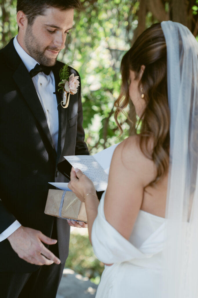 Bride reading a letter from the groom during a private gift exchange at their Laurel Court wedding.
