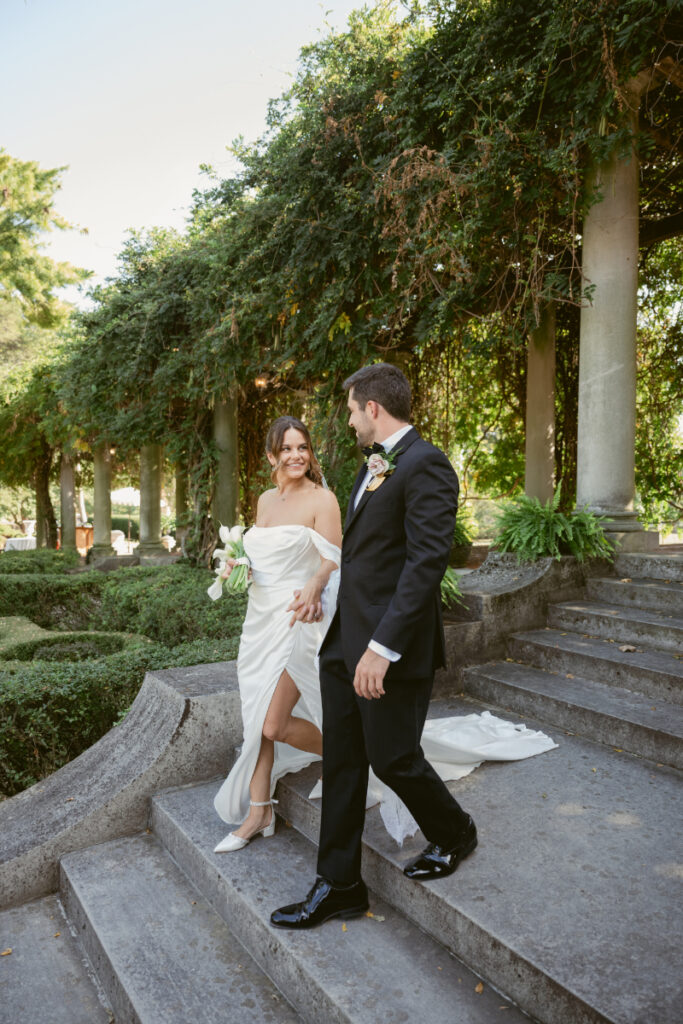 Bride and groom walking down stone steps in the garden during their Laurel Court wedding.
