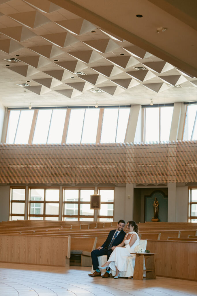 Couple sitting together quietly in church during the ceremony before their Laurel Court wedding.
