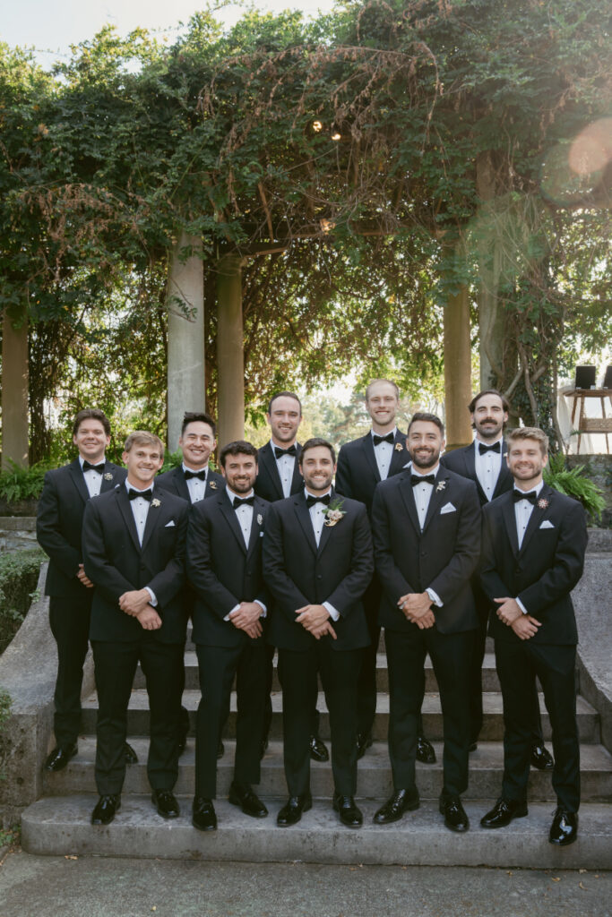 groom and his groomsmen standing in front of the steps in a garden at a Laurel Court wedding