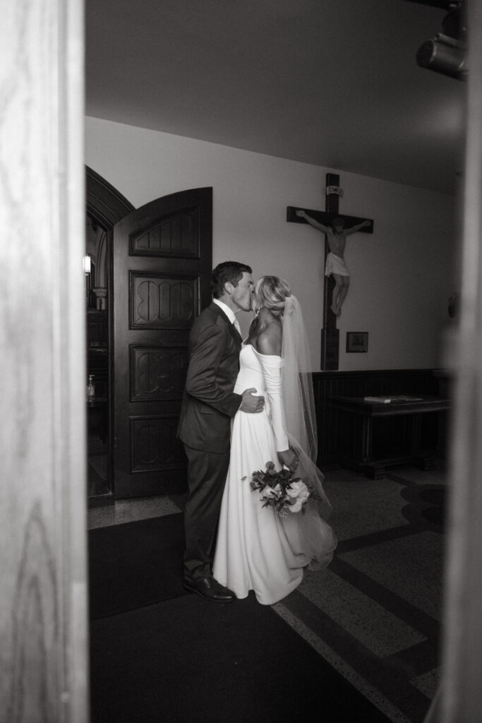 Bride and groom share a private kiss inside a chapel—one of those Moments You Won’t See on Your Wedding Day.