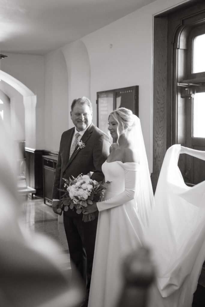 Bride smiles up at her father before walking down the aisle—touching Moments You Won’t See on Your Wedding Day.
