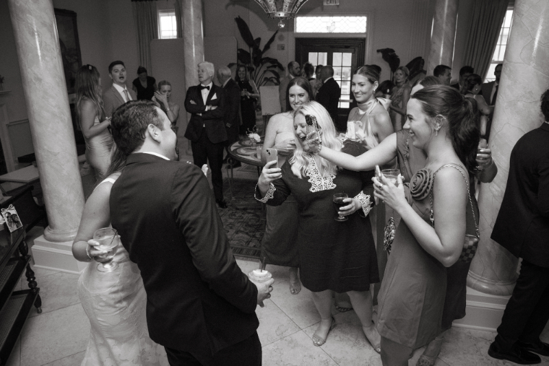 Guests raise their glasses and share a laugh during a lively cocktail hour filled with celebration.