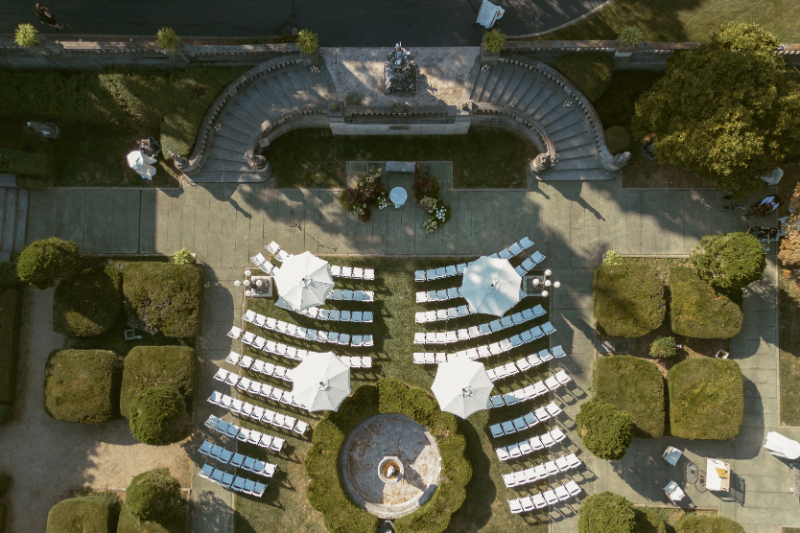 Outdoor ceremony layout with white chairs and umbrellas during Varsity Estates home renovation project planning phase.