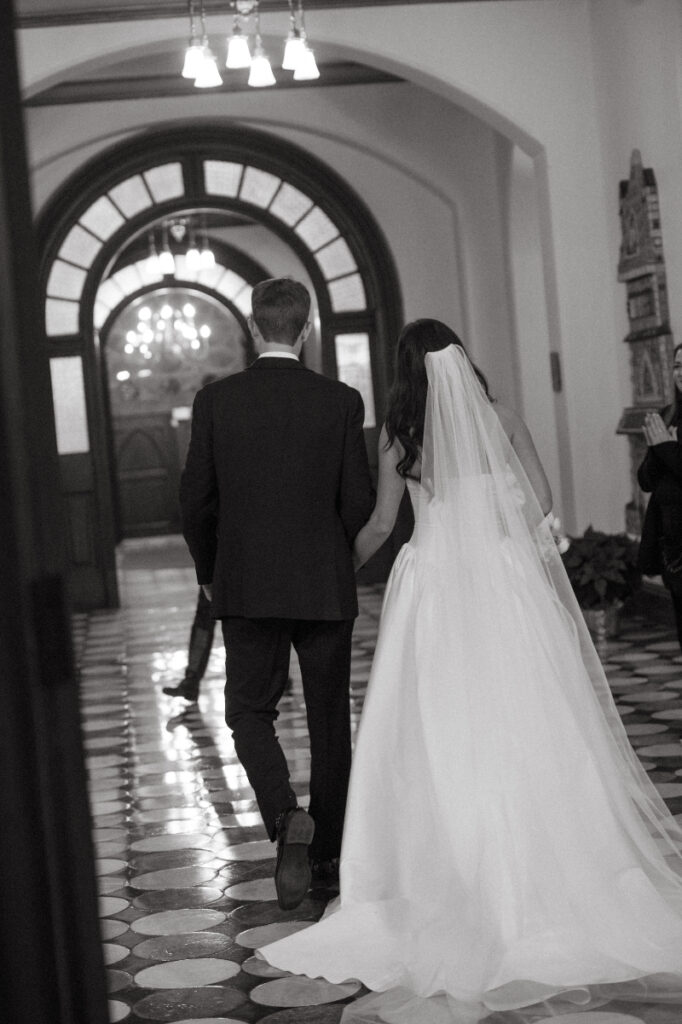 black and white photo of a bride and groom exiting the church as husband and wife 