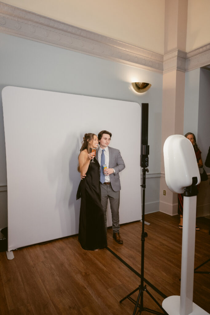 Guests pose at a modern photo booth setup during this cozy Christmas wedding celebration.