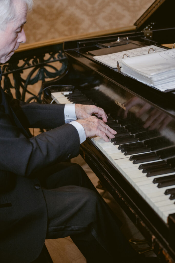 Pianist plays elegant melodies during the cozy Christmas wedding cocktail hour or reception.
