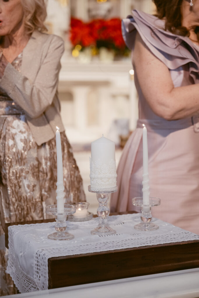 mother of the bride and mother of the groom lighting candles in the church