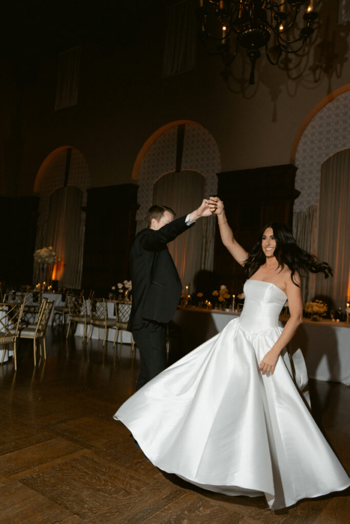 groom spinning his bride on the dancefloor at a cozy Christmas wedding 
