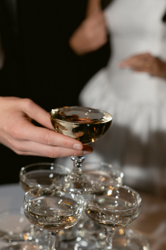 Close-up of a champagne toast during the couple’s cozy Christmas wedding celebration.