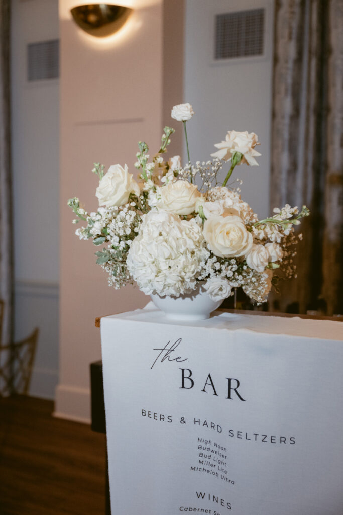 Elegant white florals decorate the bar at this cozy Christmas wedding celebration.