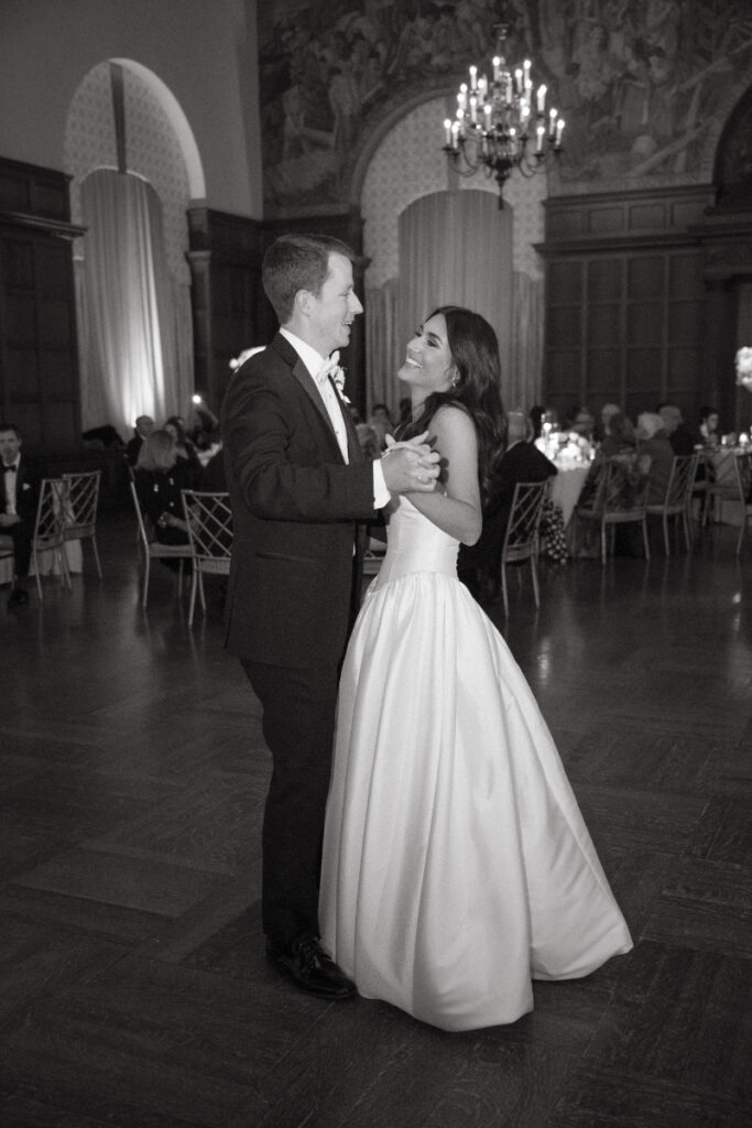 The couple shares a romantic first dance on the reception floor, surrounded by soft candlelight and elegant décor.