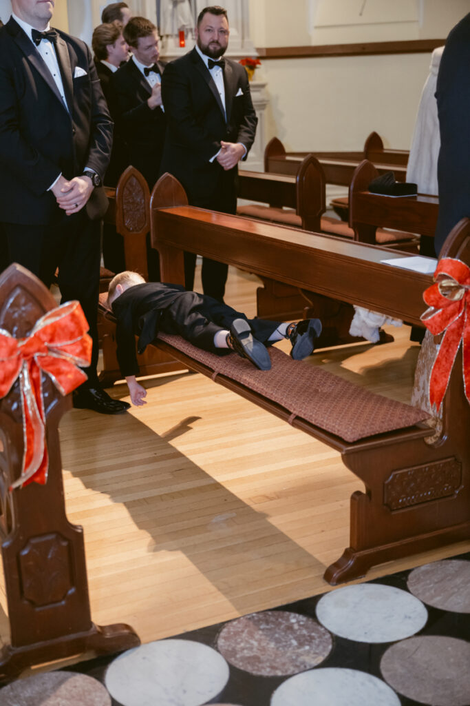 you boy sleeping on a bench at a cozy christmas wedding 