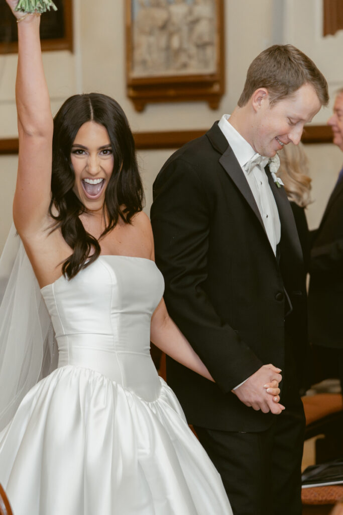 bride holding the grooms hand making their exit after their wedding ceremony 
