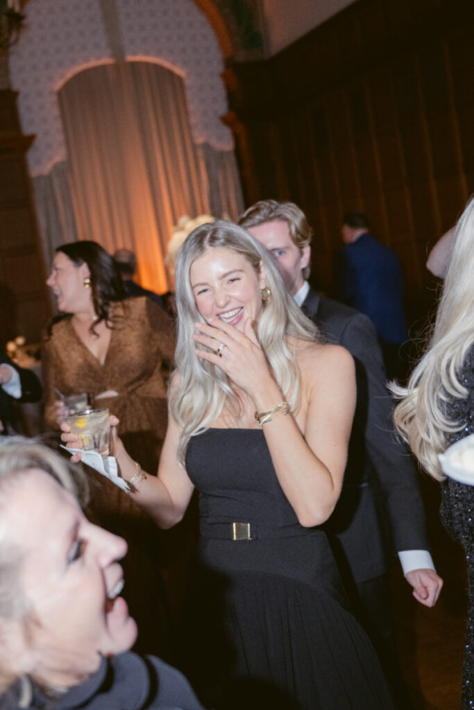 Guests laugh and enjoy themselves on the dance floor, drinks in hand.