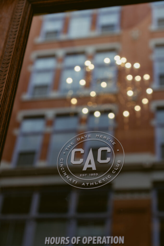 Cincinnati Athletic Club entrance with chandelier reflection before cozy Christmas wedding celebration.