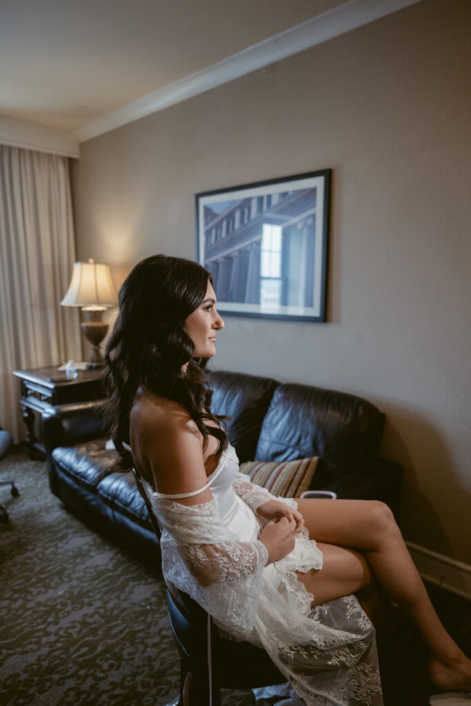 Bride sitting in robe before her cozy Christmas wedding, getting ready at downtown Cincinnati hotel.