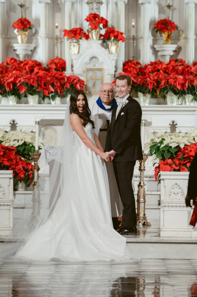 bride and groom just married and the bride is looking at the guests with a big smile 